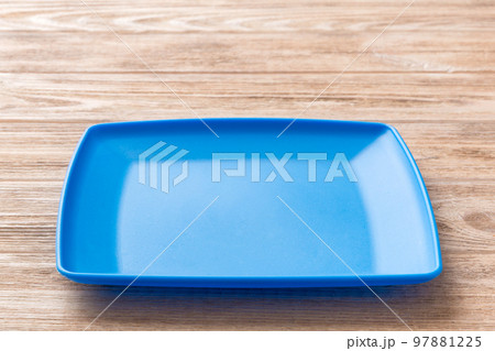 Perspective view of empty square plate on wooden background. Empty space for your design 97881225