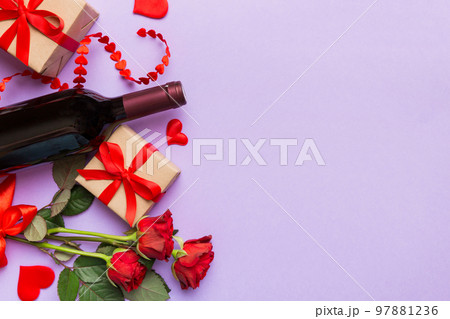 Valentine's day composition with red wine, rose flower and gift box on table. Top view, flat lay. Holiday concept Valentine's day composition with red wine, rose flower and gift box on table. Top view, flat lay. Holiday concept 97881236