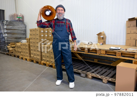Contented warehouse loader posing for the camera at work Contented warehouse loader posing for the camera at work 97882011