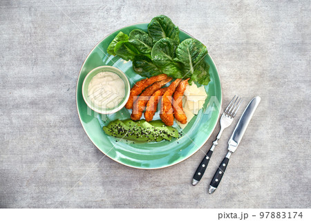 shrimp tempura with avocado, parmesan and vegetables close-up on a plate on a table 97883174