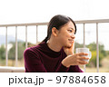 テラスでゆっくりする女性 テラスでゆっくりする女性 97884658