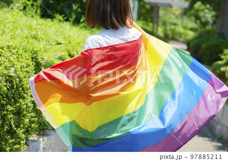 虹色の旗を持った性的マイノリティの女性の後ろ姿 97885211