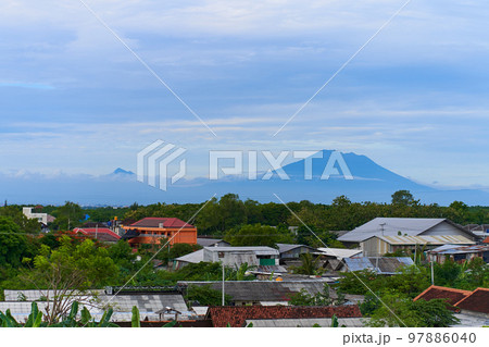 Landscape views of the majestic volcano Agung over the rooftops of the town at its foot Landscape views of the majestic volcano Agung over the rooftops of the town at its foot 97886040
