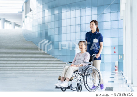 車椅子のシニア女性と若いヘルパー 車椅子のシニア女性と若いヘルパー 97886810