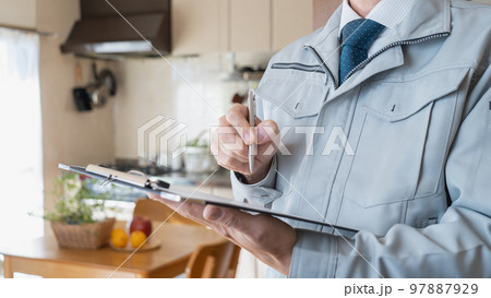 リビング・キッチンを点検する作業服の男性｜リフォーム調査・見積り　イメージ 97887929