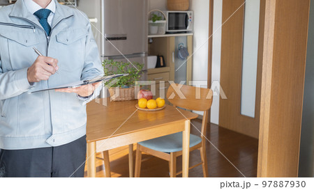 リビング・キッチンを点検する作業服の男性｜リフォーム調査・見積り　イメージ 97887930