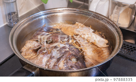キッチンで鯛のかぶと煮(あら炊き)をつくる｜和食の魚料理 97888335