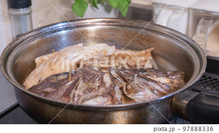 キッチンで鯛のかぶと煮(あら炊き)をつくる｜和食の魚料理 97888336