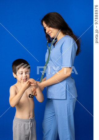 The doctor listens to the heart and lungs of a 5-year-old boy with a stethoscope. 97888976