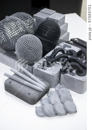 Many different models printed on 3D printer. Gray and black objects printed on 3D printer made of plastic close-up. Lots of 3D printed models. Prototypes of various shapes made by 3d printer on table. Many different models printed on 3D printer. Gray and black objects printed on 3D printer made of plastic close-up. Lots of 3D printed models. Prototypes of various shapes made by 3d printer on table. 97889701