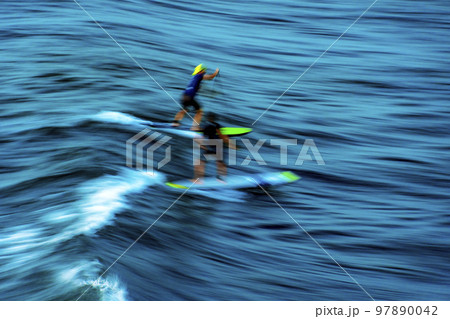 Stand up paddle on the waves at sunset in the sea of the city of Salvador Stand up paddle on the waves at sunset in the sea of the city of Salvador 97890042