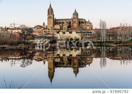 Scenic view of Salamanca at sunset with the cathedral reflected in the Tormes river Scenic view of Salamanca at sunset with the cathedral reflected in the Tormes river 97890792