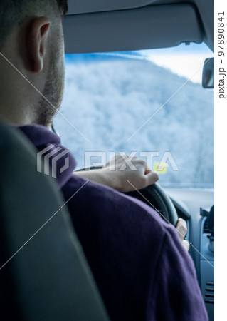 man close up driving car by snowed road man close up driving car by snowed road 97890841