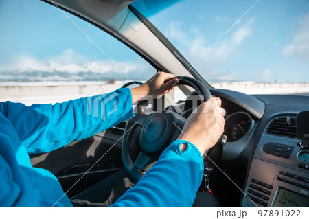 man hands on steering wheel winter road trip man hands on steering wheel winter road trip 97891022