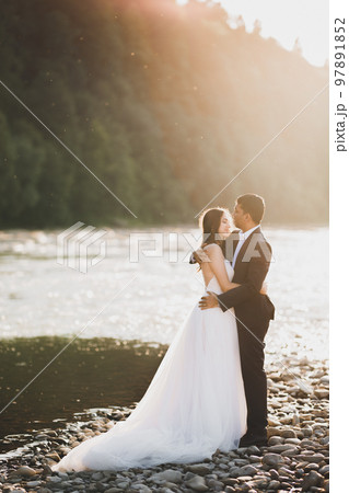 Romantic wedding moment, couple of newlyweds smiling portrait, bride and groom hugging 97891852