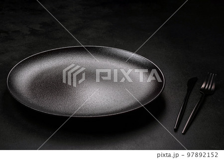 Empty beautiful black ceramic plate on a dark concrete background 97892152