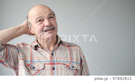 Senior hispanic man trying to remember something or having terrible headache. 97892813