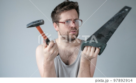 Young caucasian worker man holding a hammer isolated on grey background 97892914