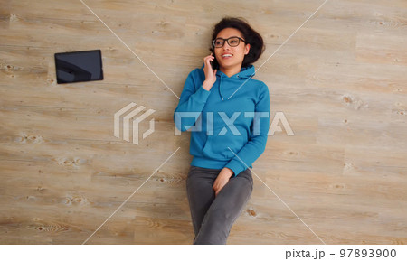 Young woman lies on the floor and makes phone calls 97893900