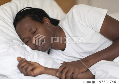 Closeup Shot Of Young African American Guy Sleeping In Bed At Home Closeup Shot Of Young African American Guy Sleeping In Bed At Home 97894746