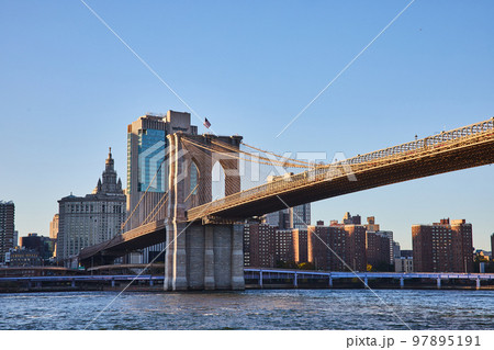 Brooklyn Bridge in New York City with city skyline in background along river Brooklyn Bridge in New York City with city skyline in background along river 97895191