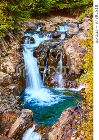 Beautiful blue waterfalls pouring into buckets of rock with forest around Beautiful blue waterfalls pouring into buckets of rock with forest around 97895518