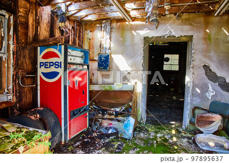 Abandoned Pepsi vending machine in front entrance of abandoned building Abandoned Pepsi vending machine in front entrance of abandoned building 97895637