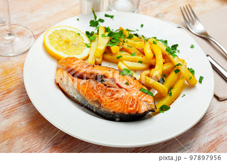 Italian dish of tasty steak of baked salmon with french fries Italian dish of tasty steak of baked salmon with french fries 97897956