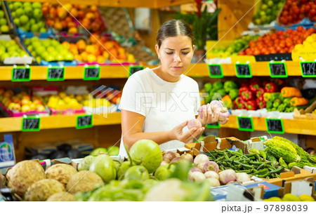Focused girl buyer chooses fresh products Focused girl buyer chooses fresh products 97898039