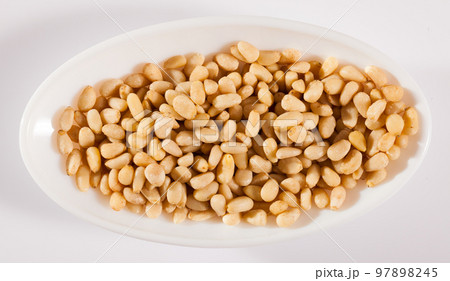 Pile of delicious pine nuts on a white surface 97898245