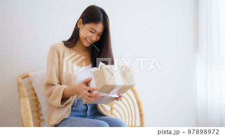 Asian young woman opening a gift box. Happy new year, Thanksgiving 97898972