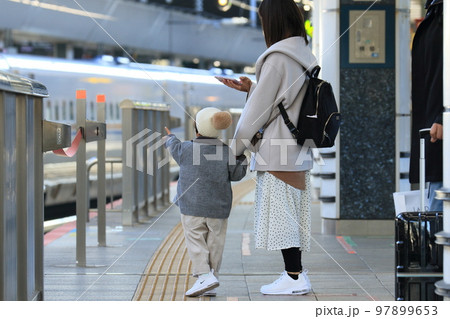 新幹線を見て喜ぶ子どもと母親　東京駅の子どもと母親 97899653