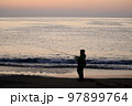 夜明け前に釣りをする男性 97899764
