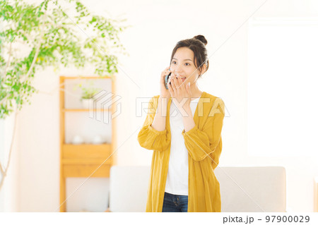 部屋で電話をする女性 部屋で電話をする女性 97900029