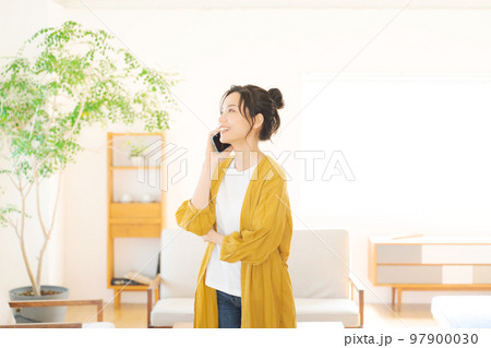 部屋で電話をする女性 97900030