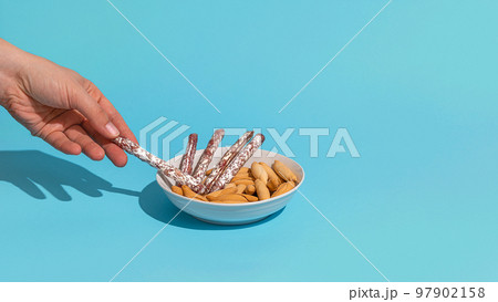 Womans hand take mini fuet from bowl Womans hand take mini fuet from bowl 97902158