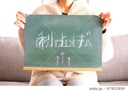 利上げの黒板と女性 97902899
