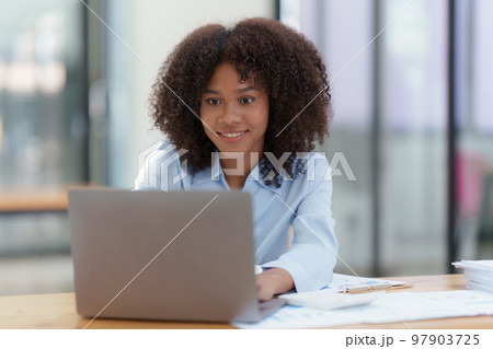 Young African American businesswoman working by laptop at office, Focus at screen laptop, reading interesting article online and finance Young African American businesswoman working by laptop at office, Focus at screen laptop, reading interesting article online and finance 97903725