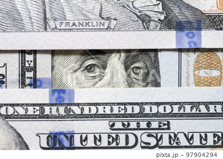 Eyes of Benjamin Franklin watching from stack of money windows 97904294
