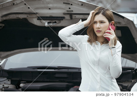 Young woman calling emergency help near broken car on road. 97904534