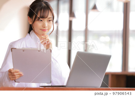 カルテを持ち考える医療事務の女性_1 カルテを持ち考える医療事務の女性_1 97906543