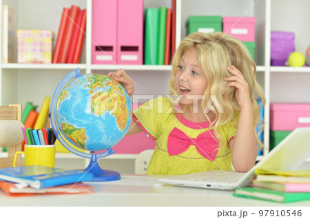 girl studying with a globe at the table girl studying with a globe at the table 97910546