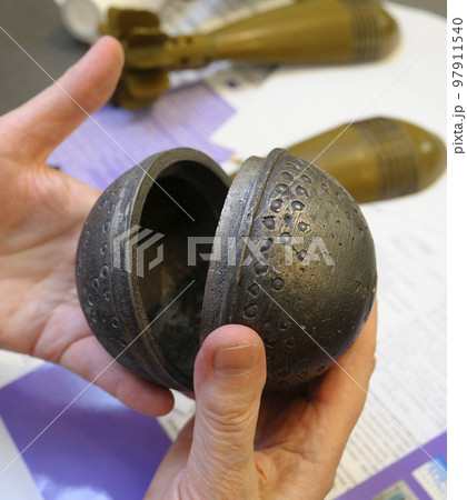 hands holding part of banned cluster bomb 97911540