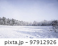 Snow covered field on a bright winter day 97912926