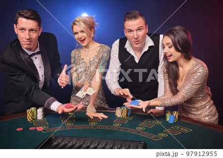 Group of a stylish rich friends are playing poker at casino. Group of a stylish rich friends are playing poker at casino. 97912955