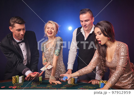 Group of a stylish rich friends are playing poker at casino. Group of a stylish rich friends are playing poker at casino. 97912959