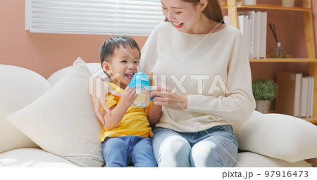 little boy drinking water 97916473