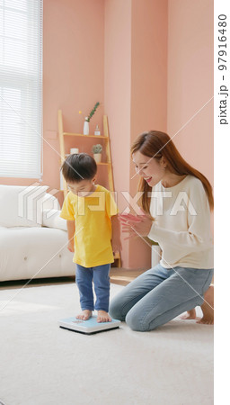 child standing on a scale child standing on a scale 97916480