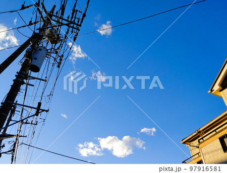 広がる青空と住宅と電信柱（青空背景） 97916581