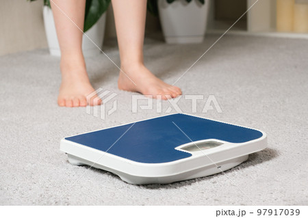 Bare feet and a floor blue scale, the concept of losing weight. Bare feet and a floor blue scale, the concept of losing weight. 97917039